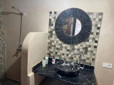 a bathroom with a sink and a mirror at Riad Eglantine in Touggana