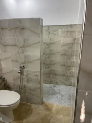 a bathroom with a toilet and a glass shower at Riad Eglantine in Touggana