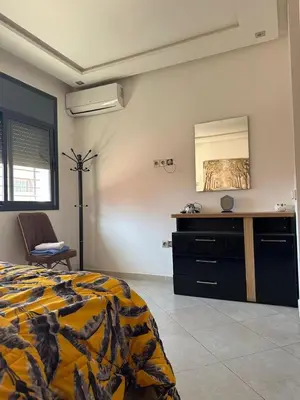 a bedroom with a bed and a mirror on the wall at Marrakech Nice Apartment- Central Marrakech in Marrakech