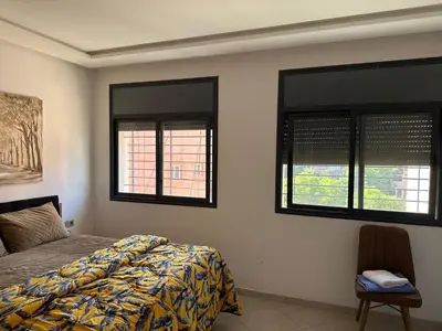 a bedroom with a bed and two windows at Marrakech Nice Apartment- Central Marrakech in Marrakech