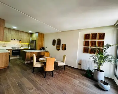 a kitchen with a table and chairs in a room at Cozy and quiet apartment in Marrakech