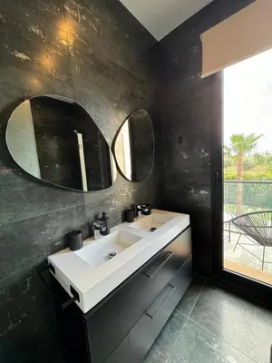 a bathroom with a white sink and two mirrors at Villa Bora in Marrakech