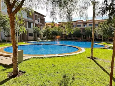 an empty swimming pool in front of a building at Appartement lumineux & élégant avec accès piscine in Marrakech