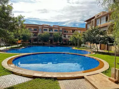 a large swimming pool in front of a building at Appartement lumineux & élégant avec accès piscine in Marrakech