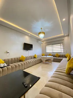 a living room with couches and a flat screen tv at Appartement lumineux & élégant avec accès piscine in Marrakech