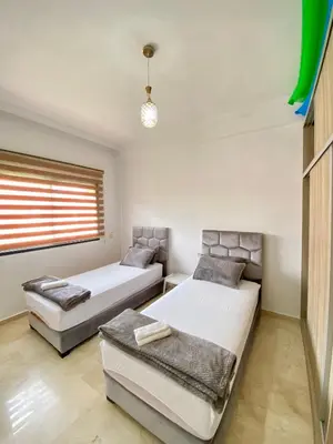 a bedroom with two beds and a window at Appartement lumineux & élégant avec accès piscine in Marrakech