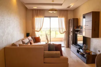 a living room with a couch and a television at Two bedroom apartment on golf resort near airport in Marrakech