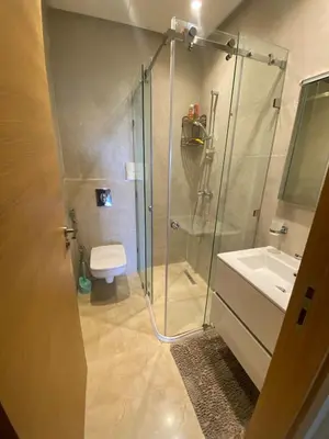 a bathroom with a shower and a toilet and a sink at Two bedroom apartment on golf resort near airport in Marrakech