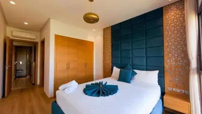 a bedroom with a large bed with a blue headboard at Two bedroom apartment on golf resort near airport in Marrakech