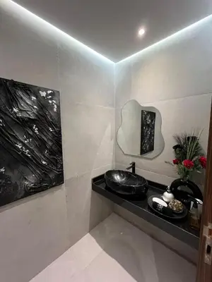 a bathroom with a sink and a mirror on a wall at Charmant appartement lumineux au cœur de la ville in Marrakech