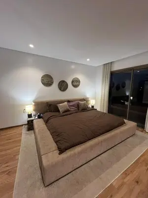 a large bed in a bedroom with two plates on the wall at Charmant appartement lumineux au cœur de la ville in Marrakech