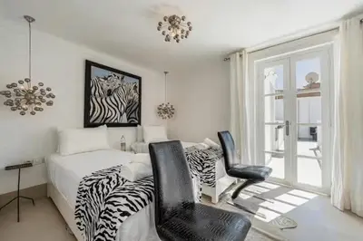 a bedroom with a zebra print bed and two chairs at Riad Byerd in Marrakech