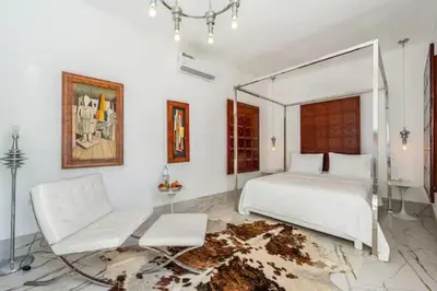 a bedroom with a white bed and a white couch at Riad Byerd in Marrakech