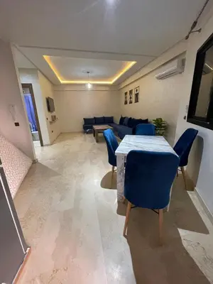 a living room with a table and blue chairs at 3wina immobilier in Marrakech