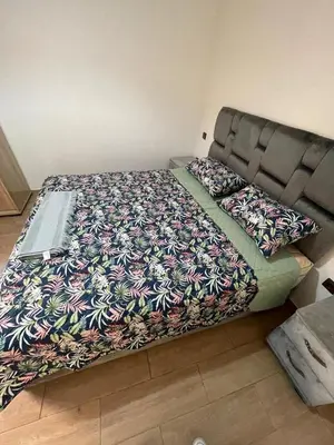 a large bed in a bedroom with a floral blanket at 3wina immobilier in Marrakech
