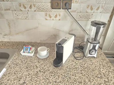 a kitchen counter with a coffee maker and a blender at Appartement ECHRIFIA GARDENS in Marrakech