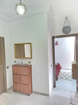 a living room with a dresser and a mirror at Appartement ECHRIFIA GARDENS in Marrakech