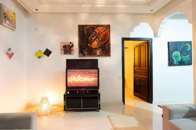 a living room with a television and a hallway with a door at Dar Yassan in Marrakech