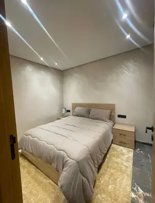 a bedroom with a large bed and lights on the ceiling at Brg Immo in Marrakech