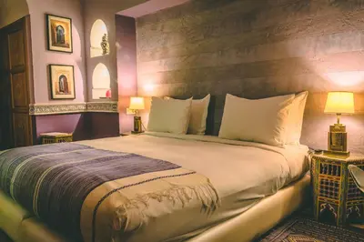 a bedroom with a large bed and two lamps at Riad Enchanté in Marrakech