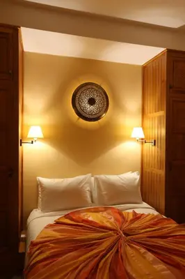 a bedroom with a large bed with two lamps at Riad Enchanté in Marrakech