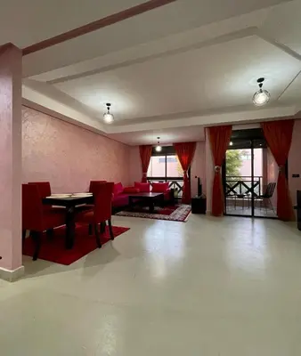 a room with tables and chairs and red chairs at Calme et sérénité 5 piscines Palmeraie in Marrakech