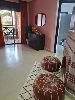 a living room with two ottomans in front of a fireplace at Calme et sérénité 5 piscines Palmeraie in Marrakech