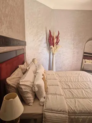 a bedroom with a bed and a vase with flowers at Calme et sérénité 5 piscines Palmeraie in Marrakech