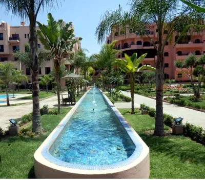 a swimming pool in a resort with palm trees at Calme et sérénité 5 piscines Palmeraie in Marrakech