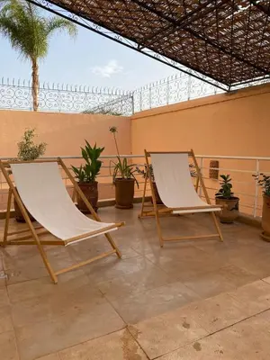 two chairs sitting on a patio with plants at Peaceful Retreat with pool in Marrakech