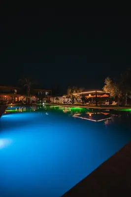 a large pool of blue water at night at MVIEW Villas in Marrakech