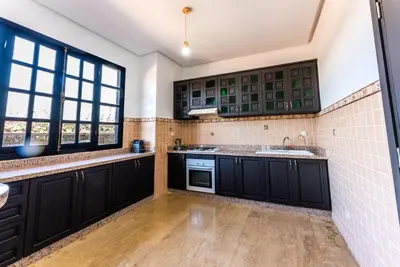 a kitchen with black cabinets and a sink at MVIEW Villas in Marrakech