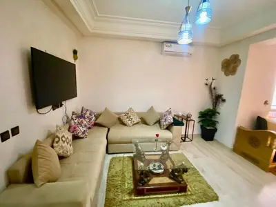 a living room with a couch and a flat screen tv at Agréable, cosy, proche du centre in Marrakech