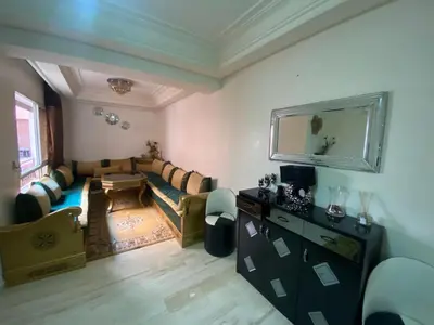 a living room with a couch and a mirror at Agréable, cosy, proche du centre in Marrakech