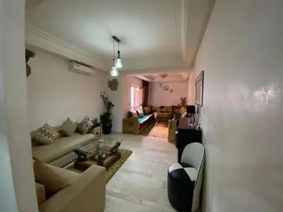 a living room with a couch and a table at Agréable, cosy, proche du centre in Marrakech