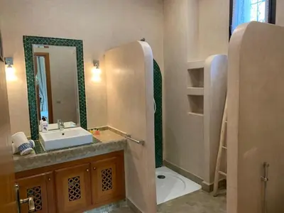 a bathroom with a sink and a mirror and a toilet at Amour de Nuits in Douar Caïd Layadi