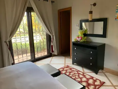 a bedroom with a bed and a dresser and a mirror at Amour de Nuits in Douar Caïd Layadi