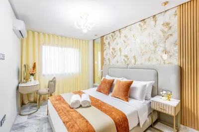 a bedroom with a large bed with orange and white pillows at Guéliz Centre-Appartement Chic près Carré Eden in Marrakech