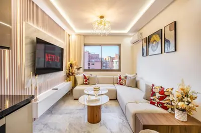 a living room with a couch and a tv at Guéliz Centre-Appartement Chic près Carré Eden in Marrakech