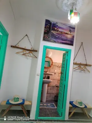 a bathroom with a green door and a mirror at ATHIKA Hostel in Marrakech