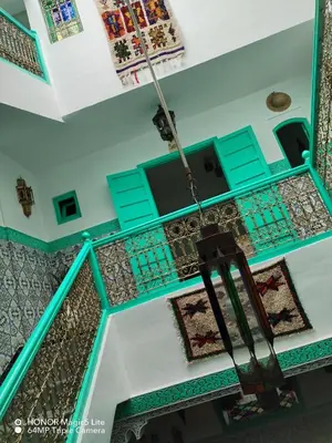 an overhead view of a stairway with turquoise and green tiles at ATHIKA Hostel in Marrakech