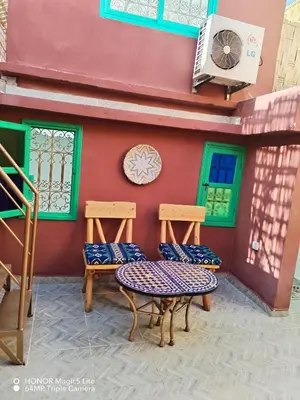 a table and two chairs outside of a house at ATHIKA Hostel in Marrakech