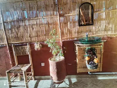 a bathroom with a sink in a straw wall at ATHIKA Hostel in Marrakech