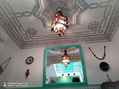 a ceiling with a chandelier and a mirror at ATHIKA Hostel in Marrakech