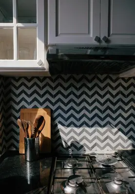 a kitchen counter with a stove top oven next to a checkered wall at Beldi-Chic & Moroccan Sweetness in Marrakech