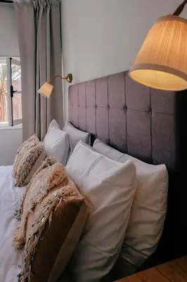 a bedroom with a bed with white pillows and a lamp at Beldi-Chic & Moroccan Sweetness in Marrakech