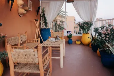 a balcony with a table and chairs and potted plants at Beldi-Chic & Moroccan Sweetness in Marrakech