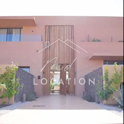 a door to a pink building with the words open audition at Villa Dar M in Marrakech