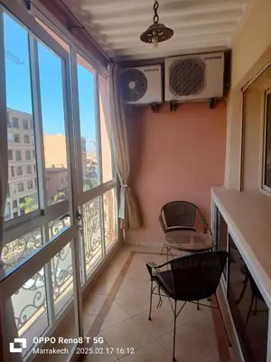 a room with two chairs and a balcony with windows at le Marrakchi in Marrakech
