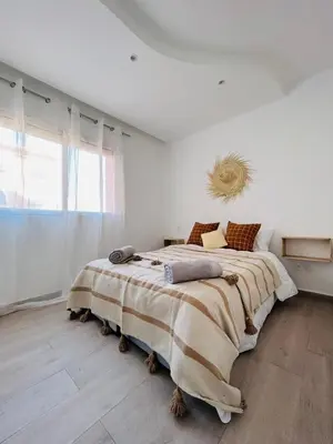 a bedroom with a large bed in a white room at The Pearl of Guelliz in Marrakech